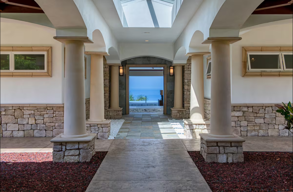 Columned entry breezeway with a skylight framing the ocean beyond the front doors