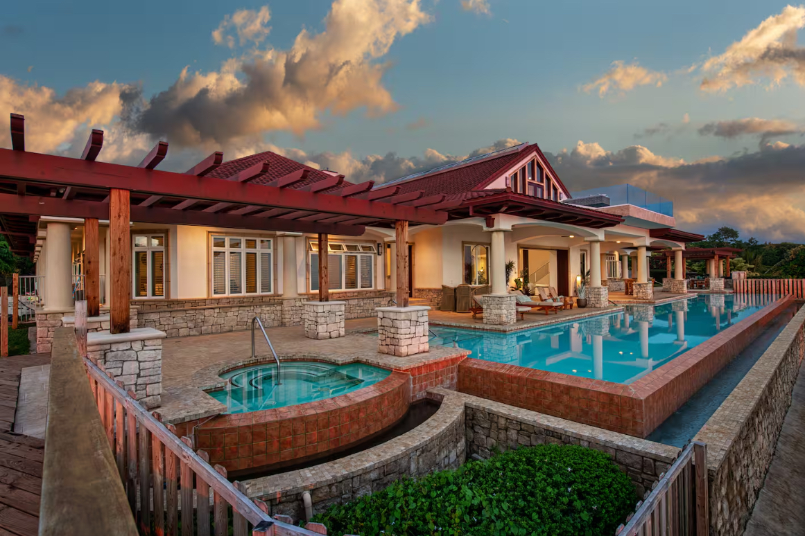 Sunset exterior of the retreat center with its pool and hot tub glowing at dusk