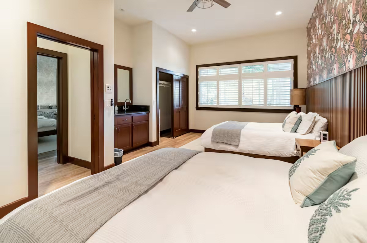 Bedroom with two large beds and warm wood finishes