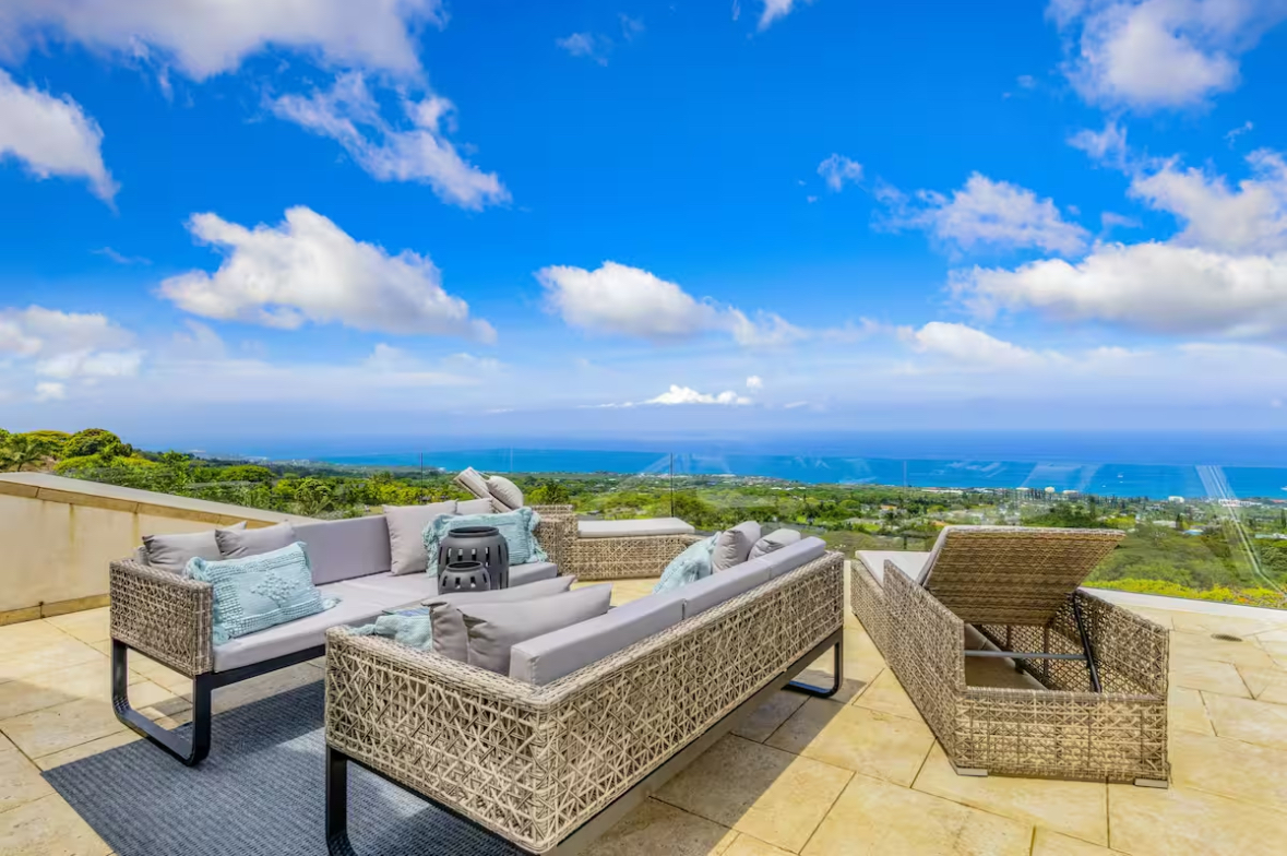 Outdoor lounge seating with a panoramic view over the Kona coastline