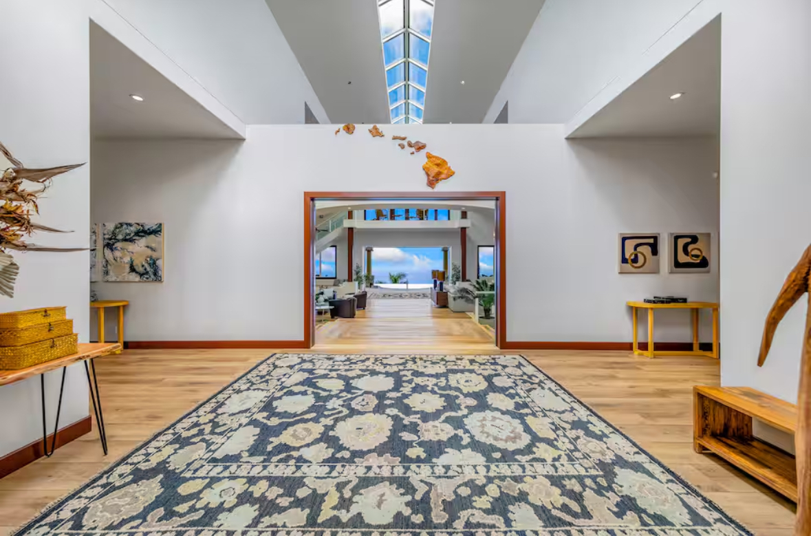 Grand entry hall with skylight leading toward the ocean-facing living area