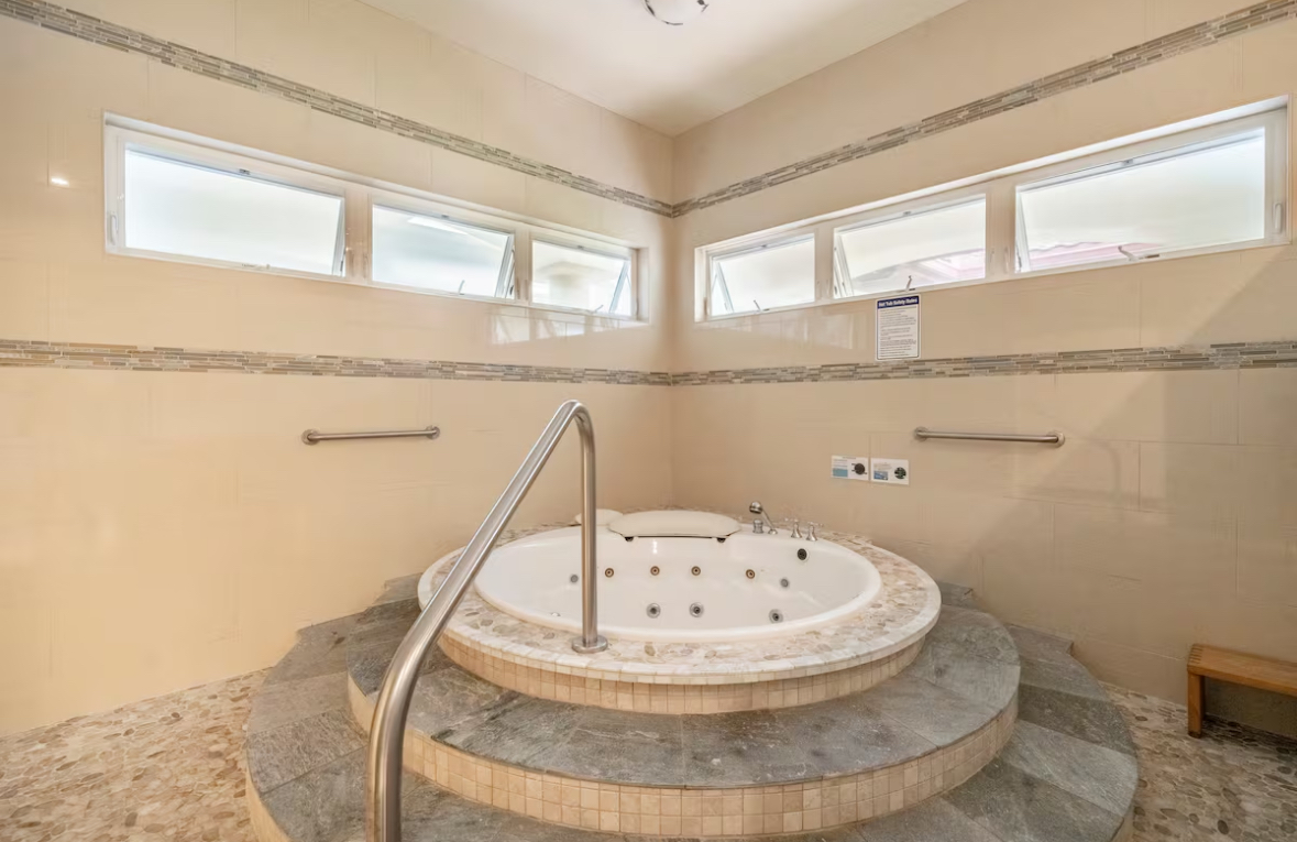 Circular soaking tub in a bright tiled spa room