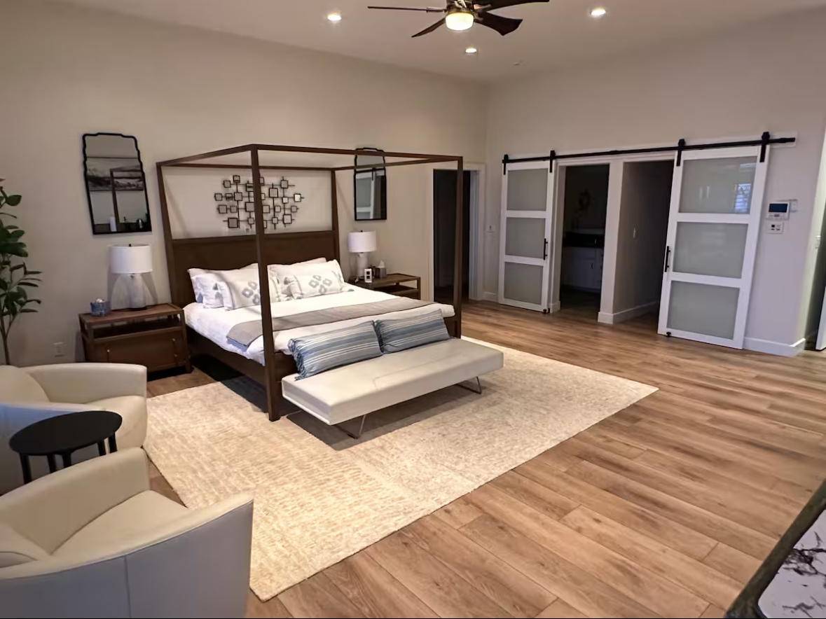 Large primary suite with a four-poster bed and expansive floor area