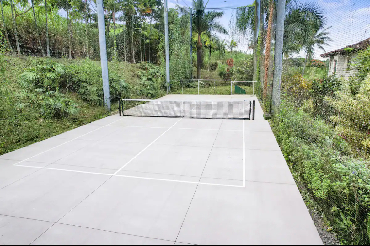 Private pickleball court surrounded by tropical landscaping