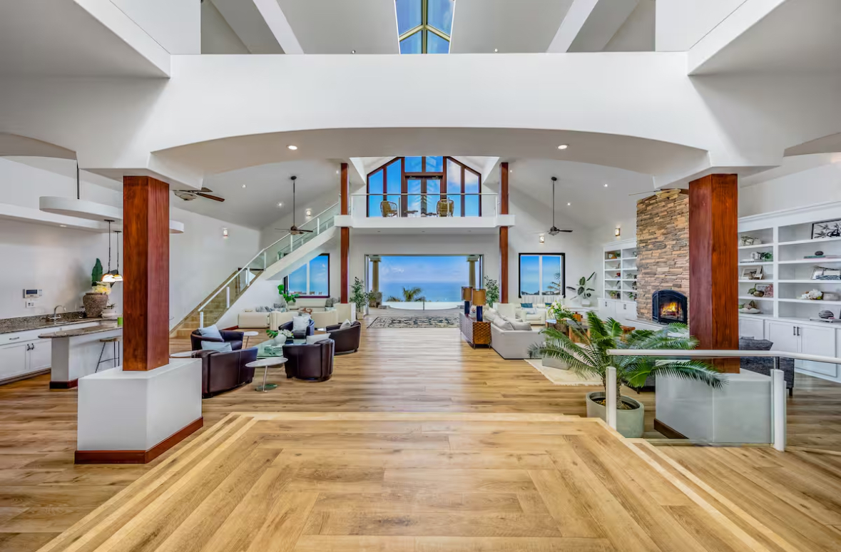 Expansive great room with soaring ceiling, kitchen, and ocean view