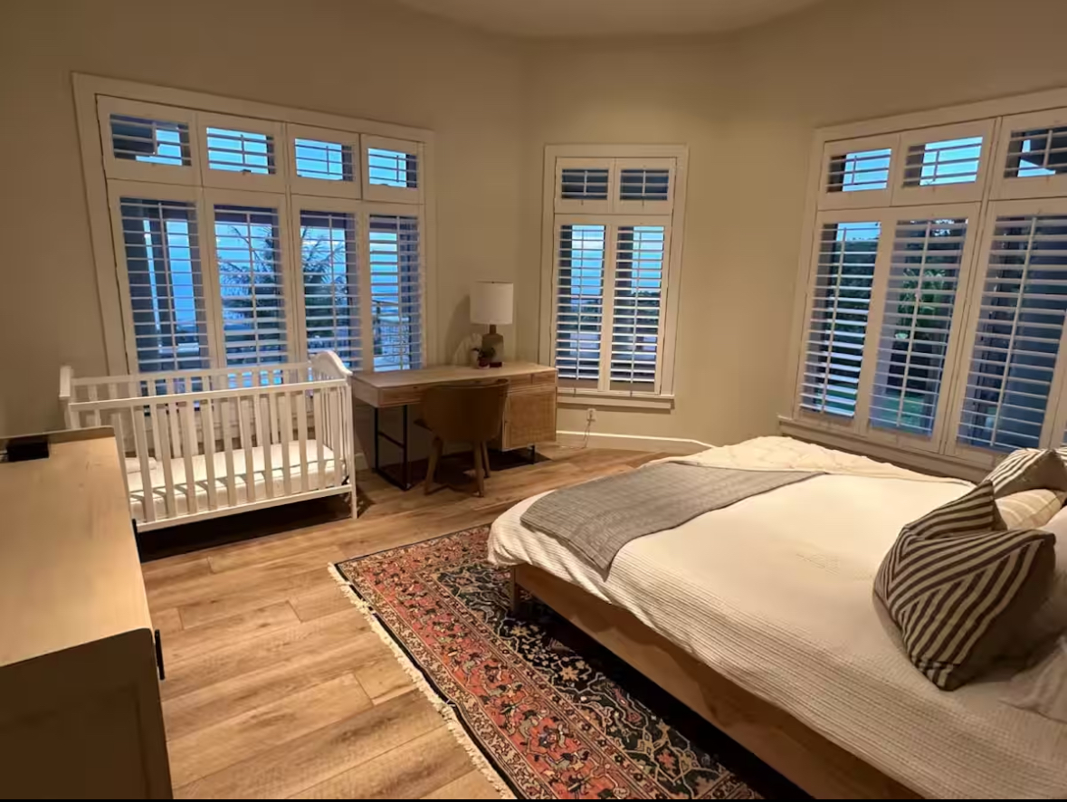 Corner bedroom with plantation shutters and an ocean glimpse
