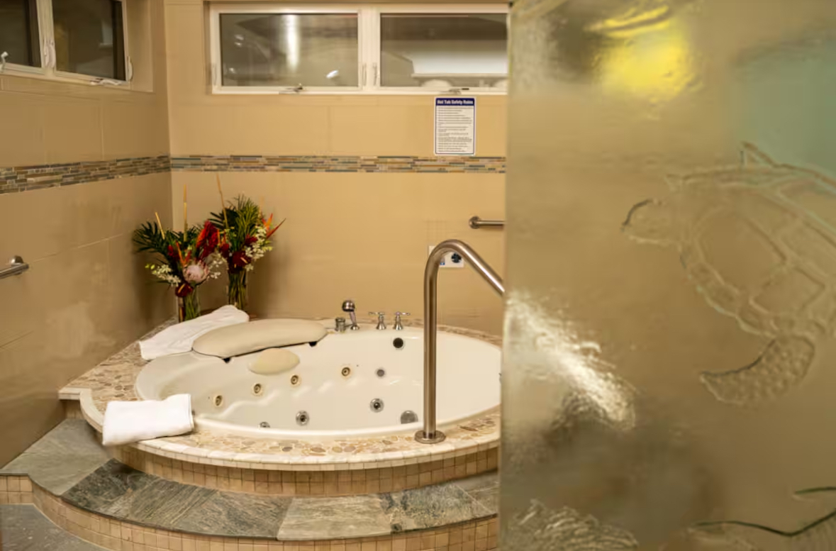 Spa room with a circular hot tub seen through textured glass