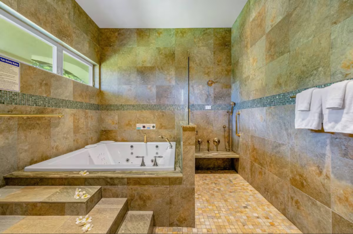 Stone-lined spa bath with soaking tub and shower area