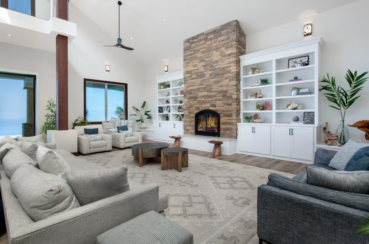 Lounge area centered around a stone fireplace and built-in shelving